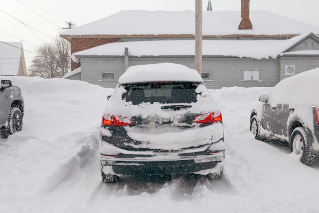 Snow-covered cars in a parking lot after a winter storm