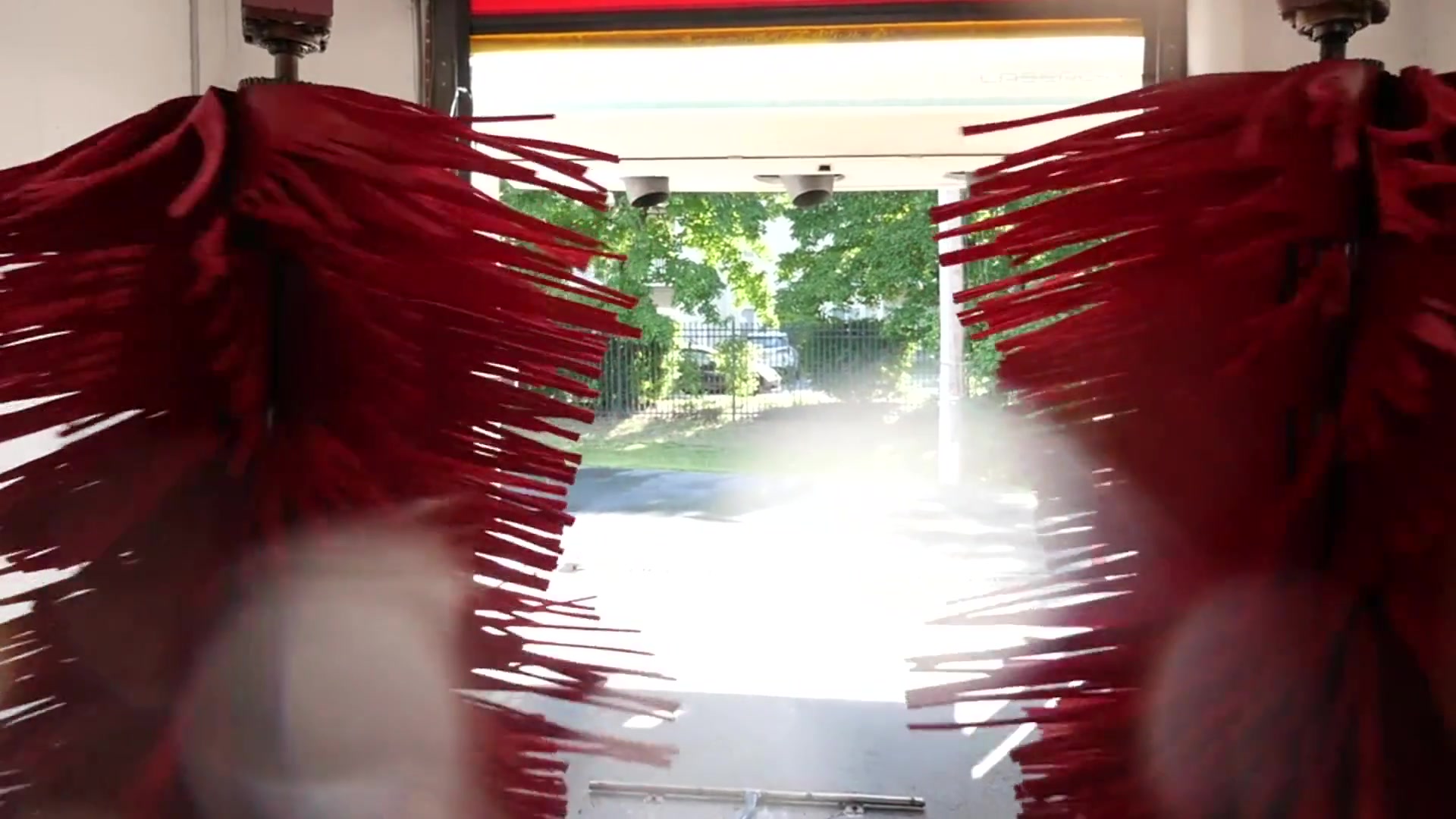 Red soft-touch brushes in an automatic car wash bay