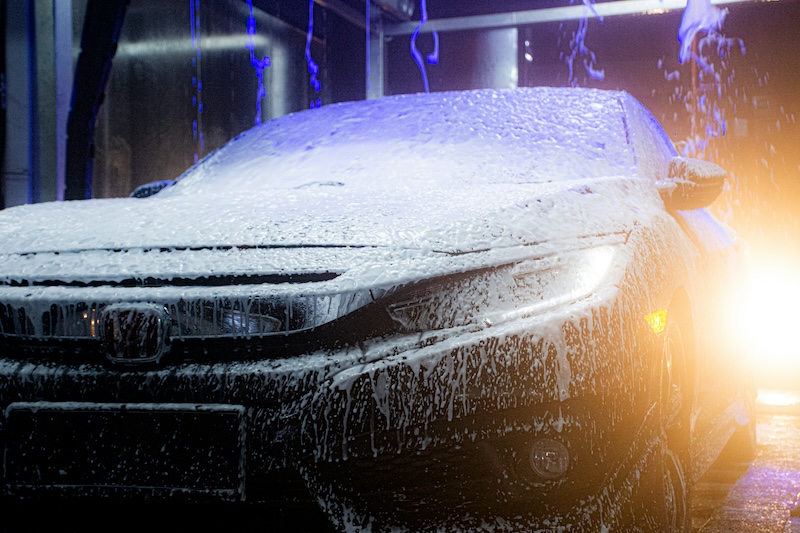 Car covered in colored foam inside an automatic car wash