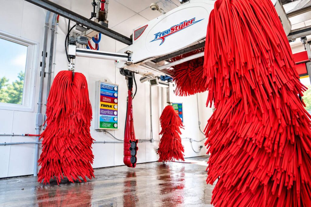 Red soft-touch brushes inside the automatic wash bay at Glen Burnie Car Wash
